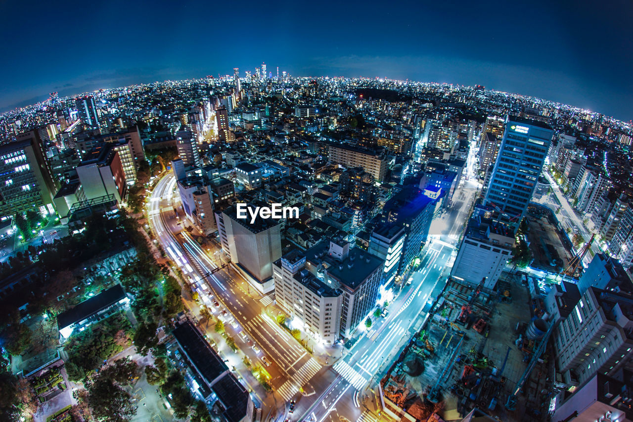 HIGH ANGLE VIEW OF ILLUMINATED BUILDINGS IN CITY