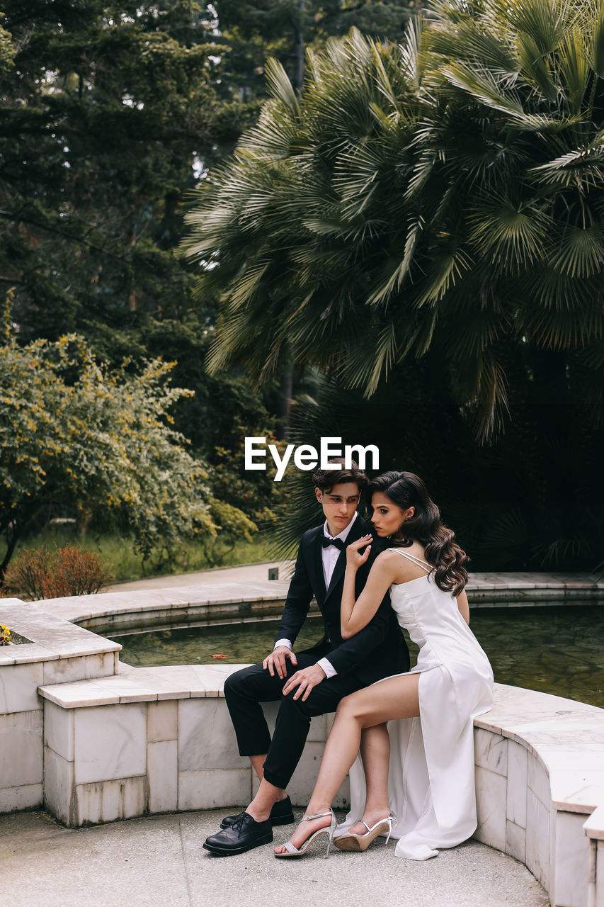 A beautiful couple in love, bride and groom in wedding clothes, walk and pose in the park in nature