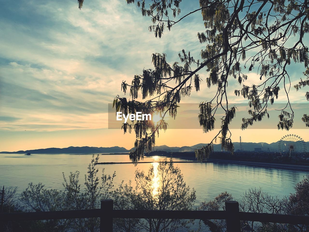 SCENIC VIEW OF LAKE AGAINST SKY AT SUNSET