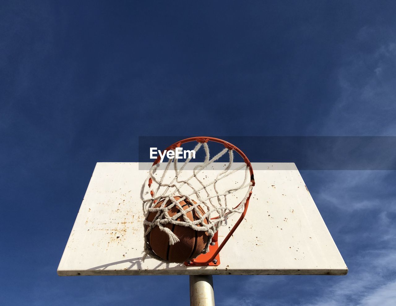 Low angle view of basketball hoop against blue sky