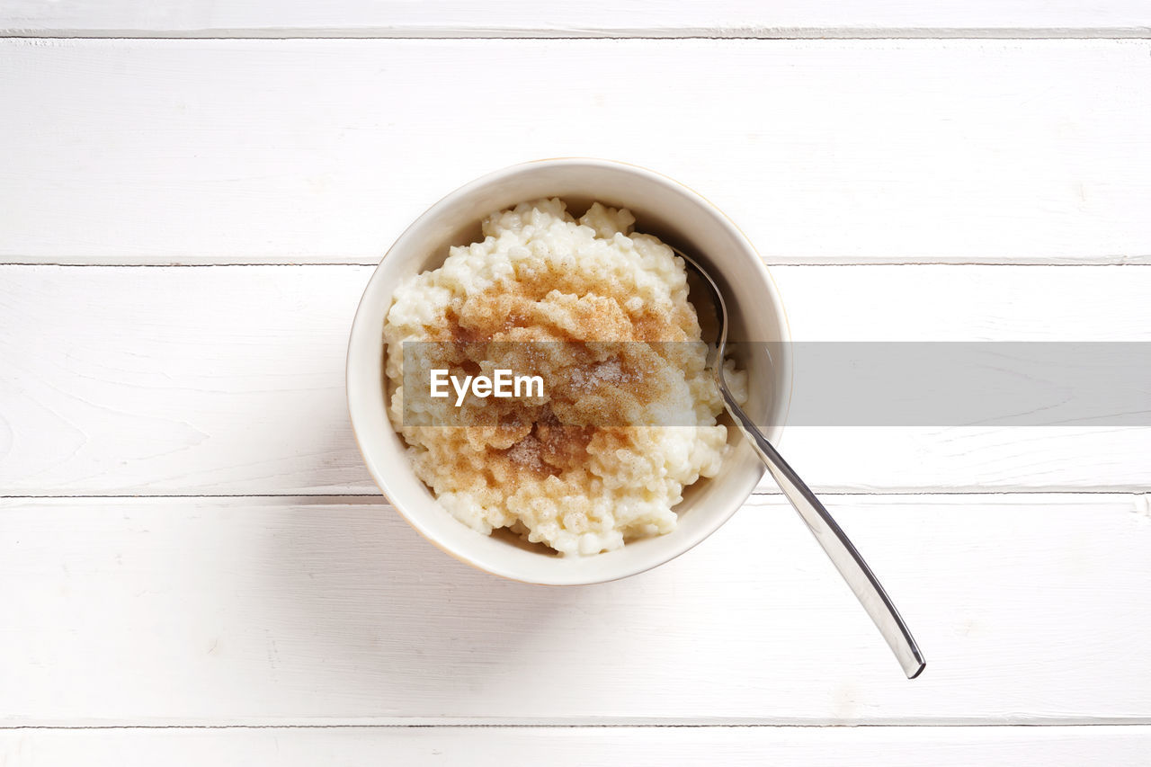 Directly above shot of rice pudding in bowl with spoon on table