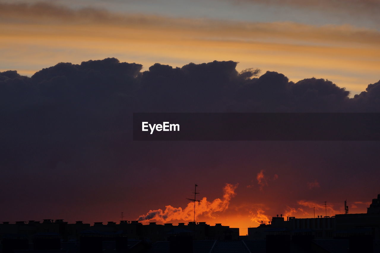 SILHOUETTE BUILDINGS AGAINST SKY DURING SUNSET