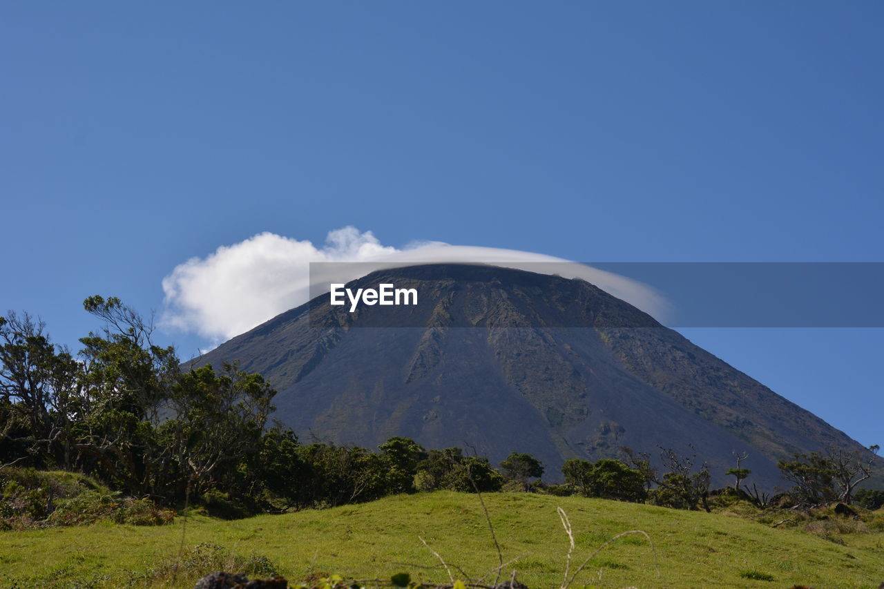 Scenic view of mountains against blue sky