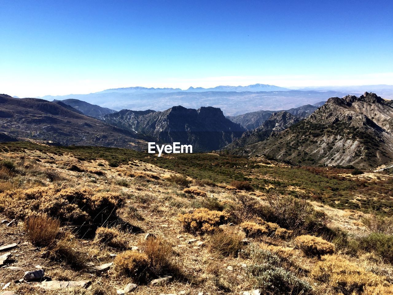 Scenic view of rocky mountains against clear blue sky