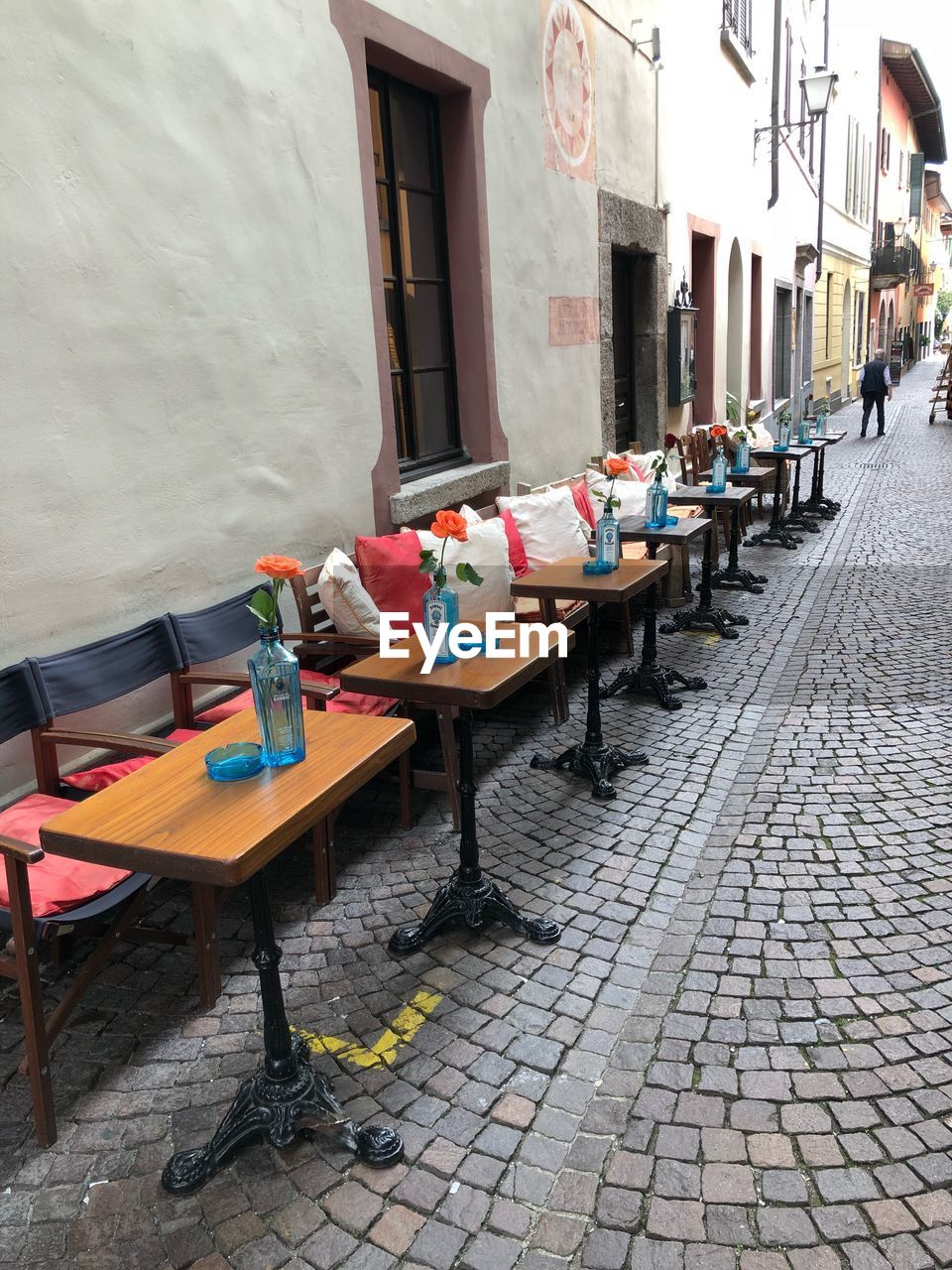 CHAIRS AND TABLES ON SIDEWALK CAFE BY BUILDINGS