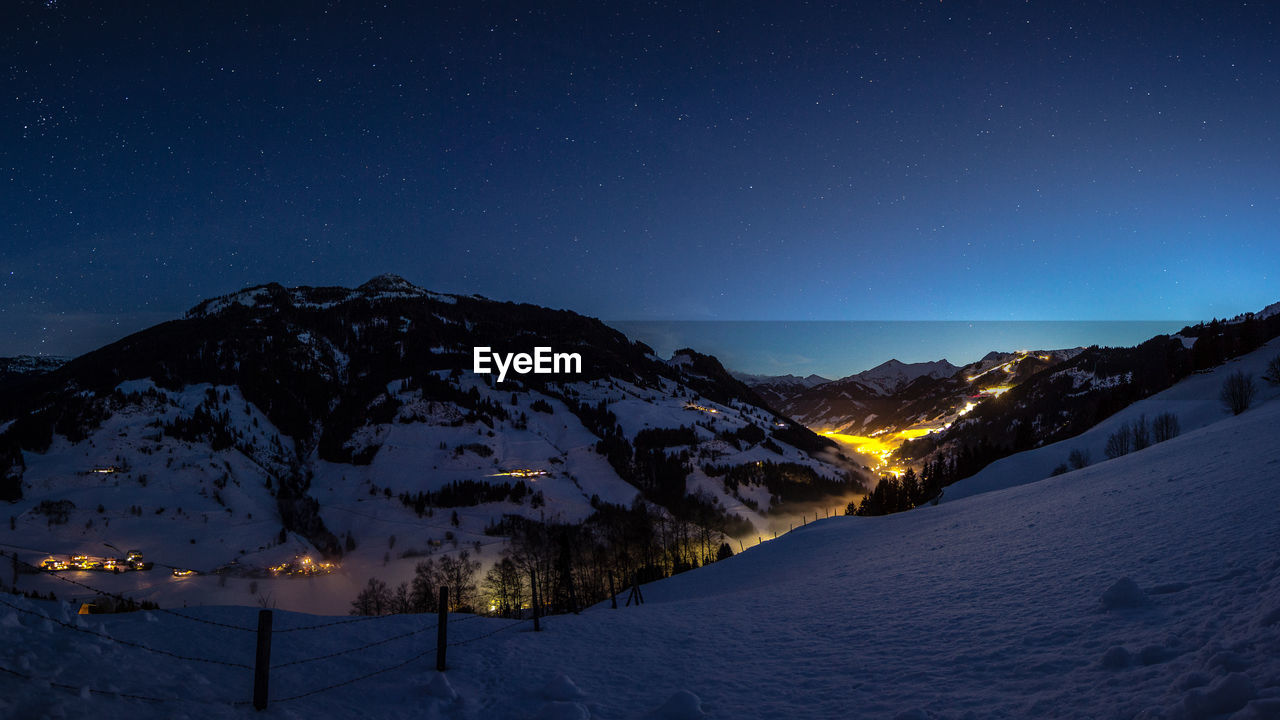 SCENIC VIEW OF SNOWCAPPED MOUNTAINS AGAINST SKY AT NIGHT