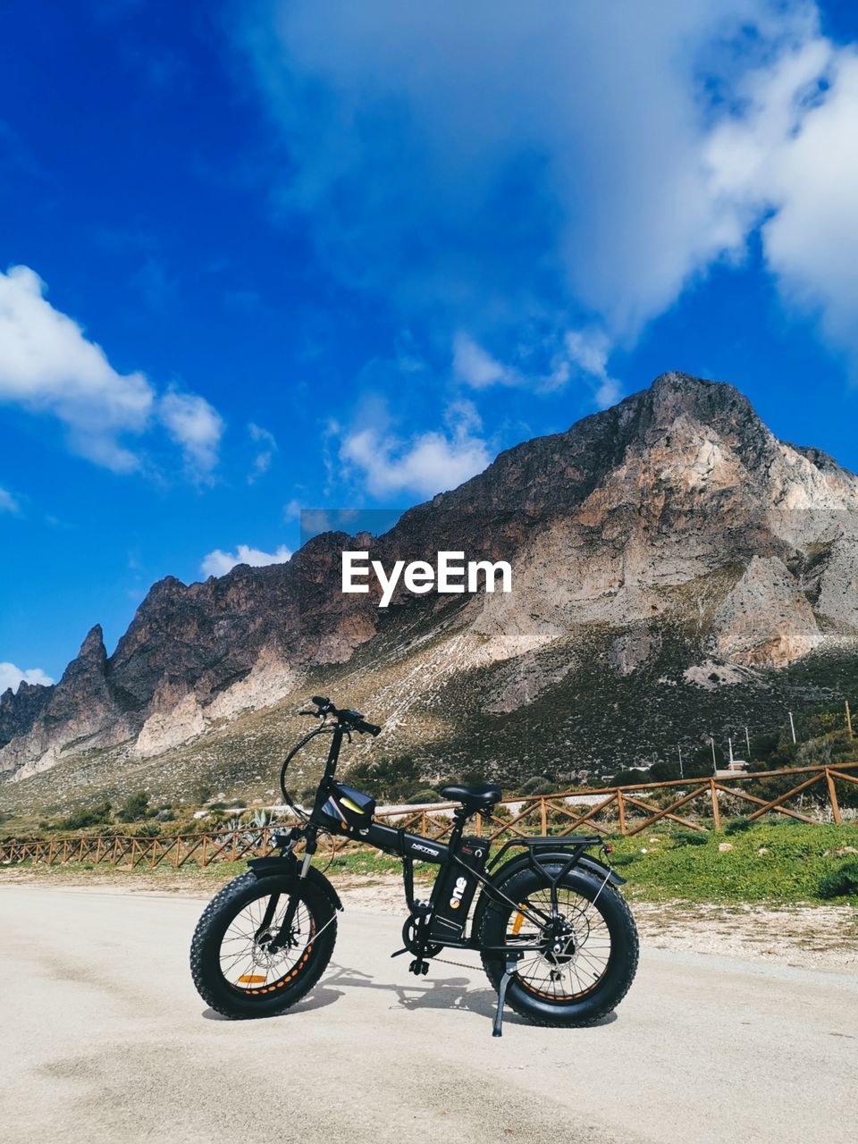 BICYCLE PARKED AGAINST MOUNTAIN RANGE