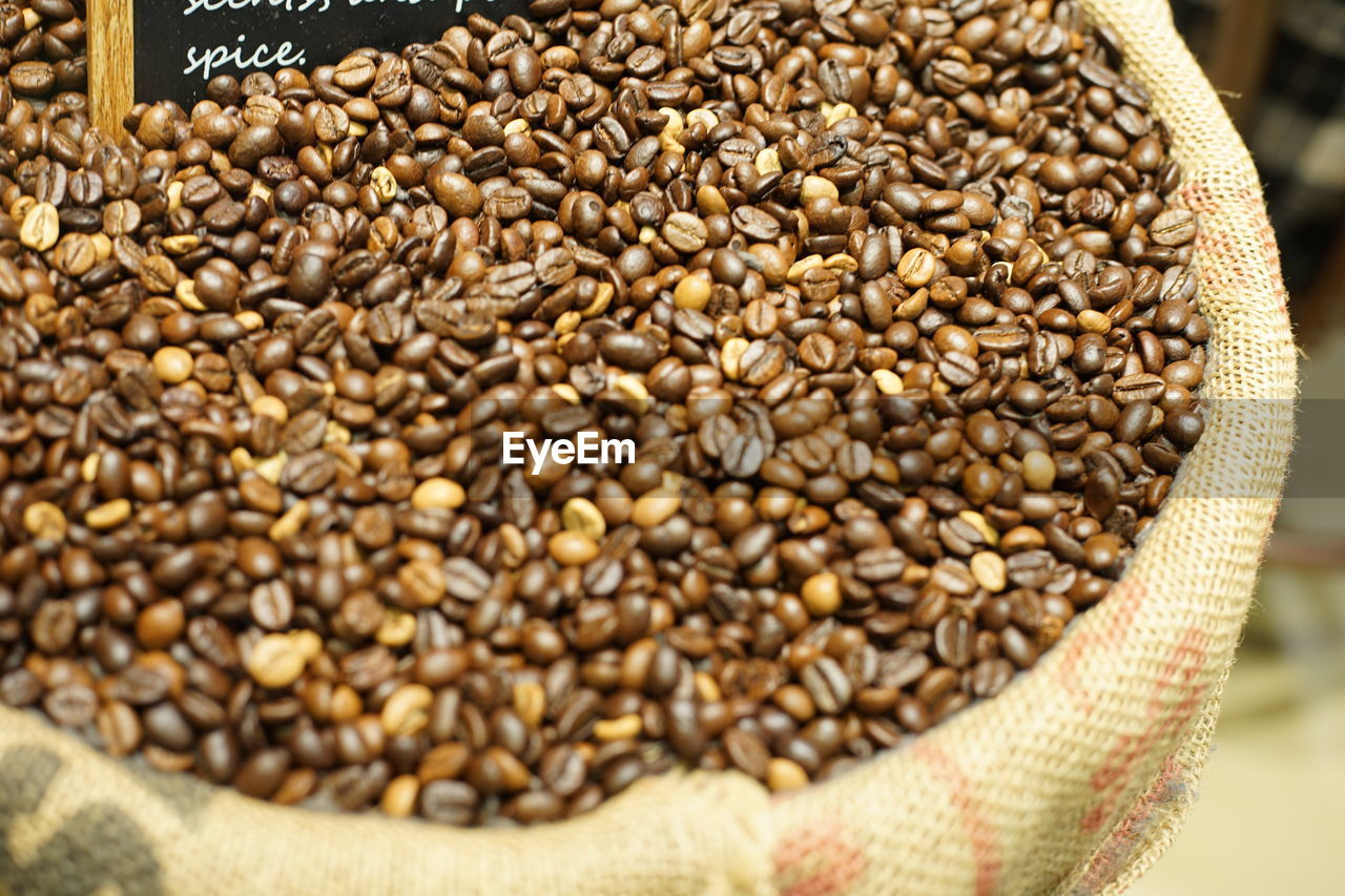HIGH ANGLE VIEW OF ROASTED COFFEE BEANS IN CONTAINER