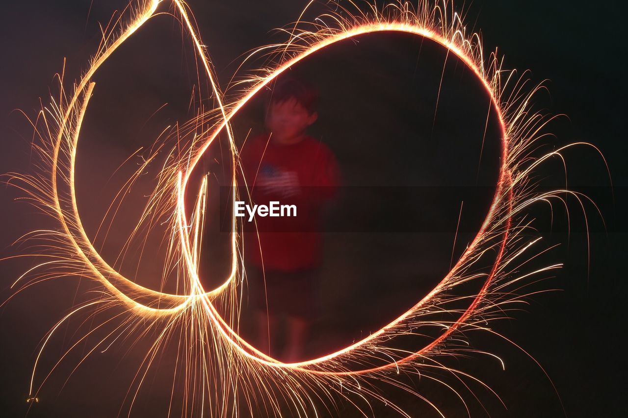 Boy performing light painting at night