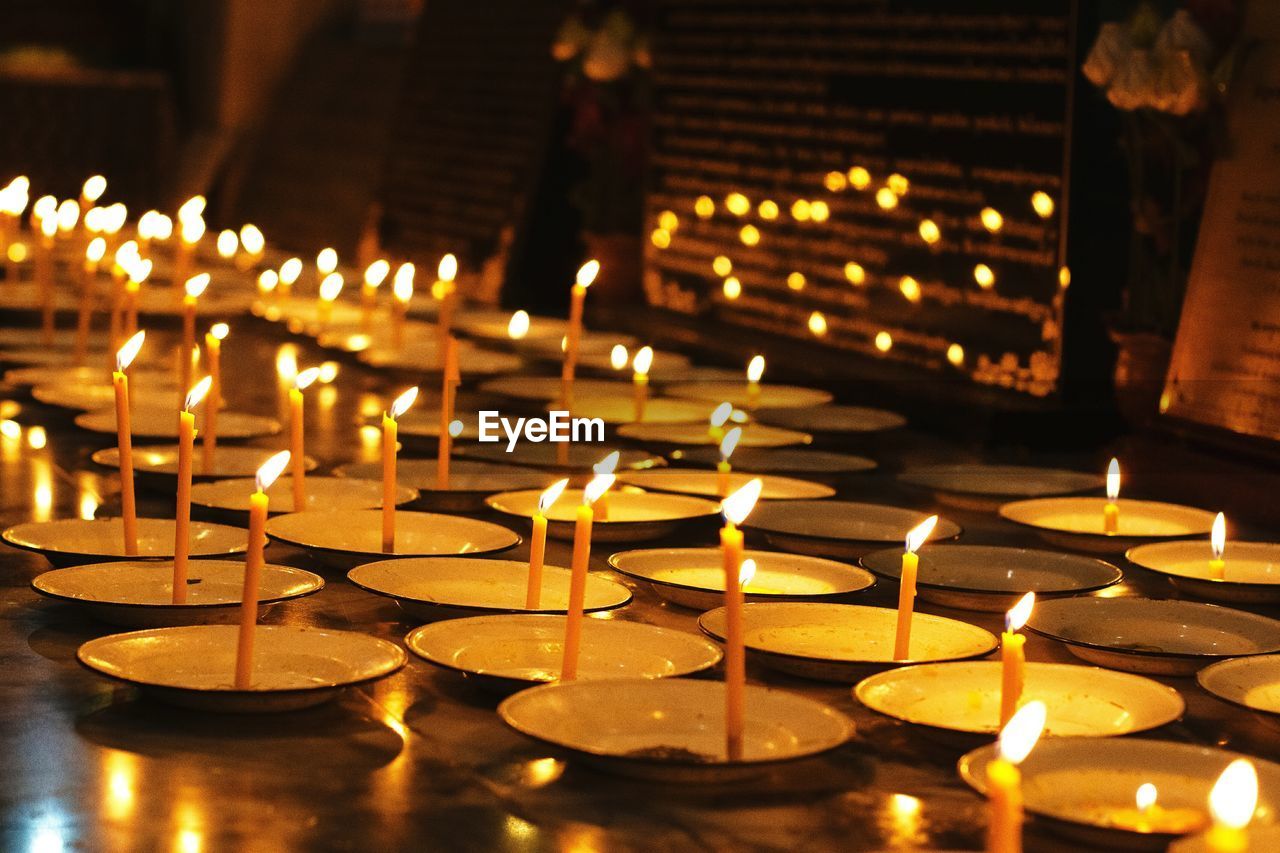 Close-up of illuminated candles in temple