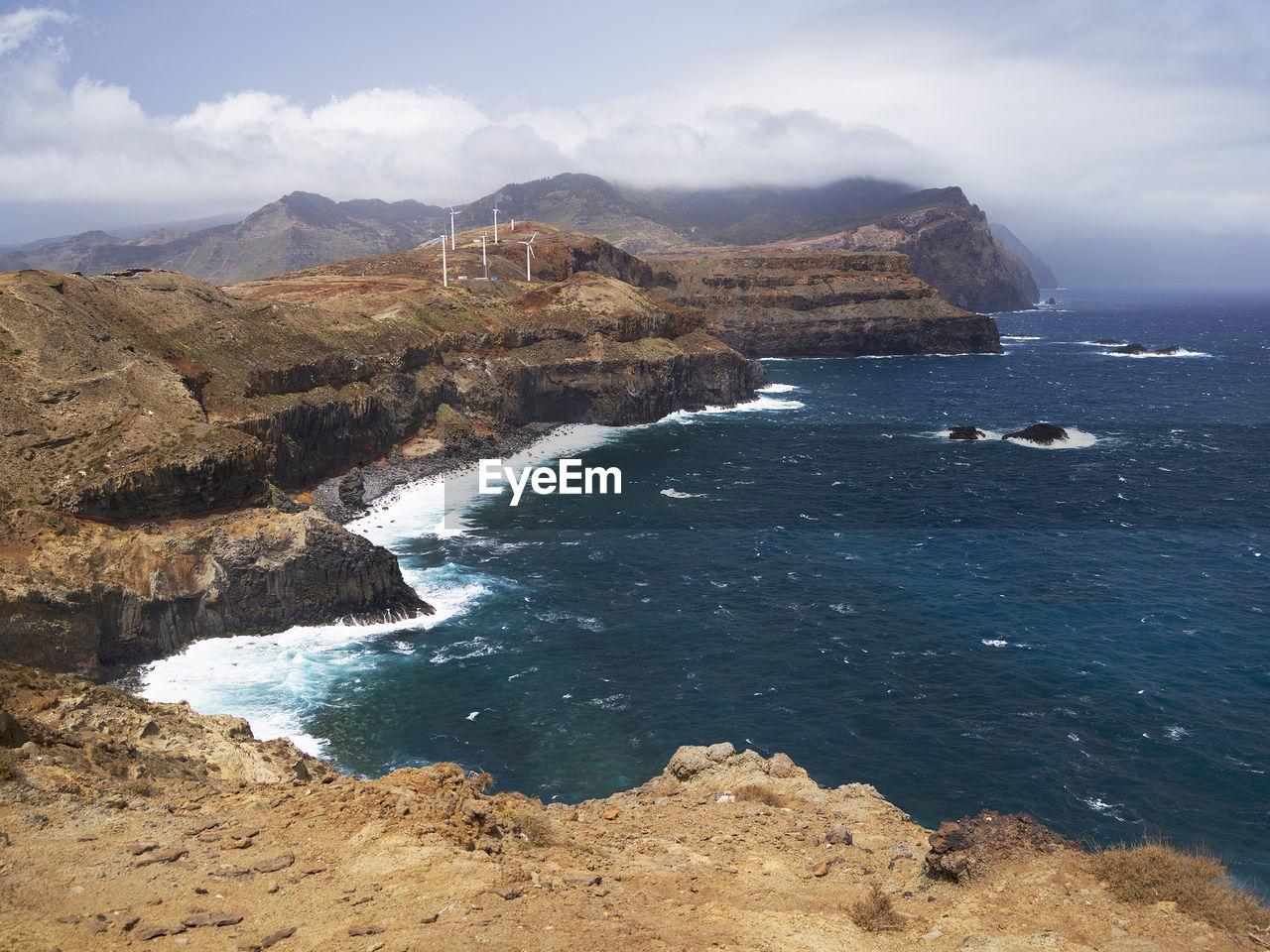 High angle view of rocky coastal feature against sky