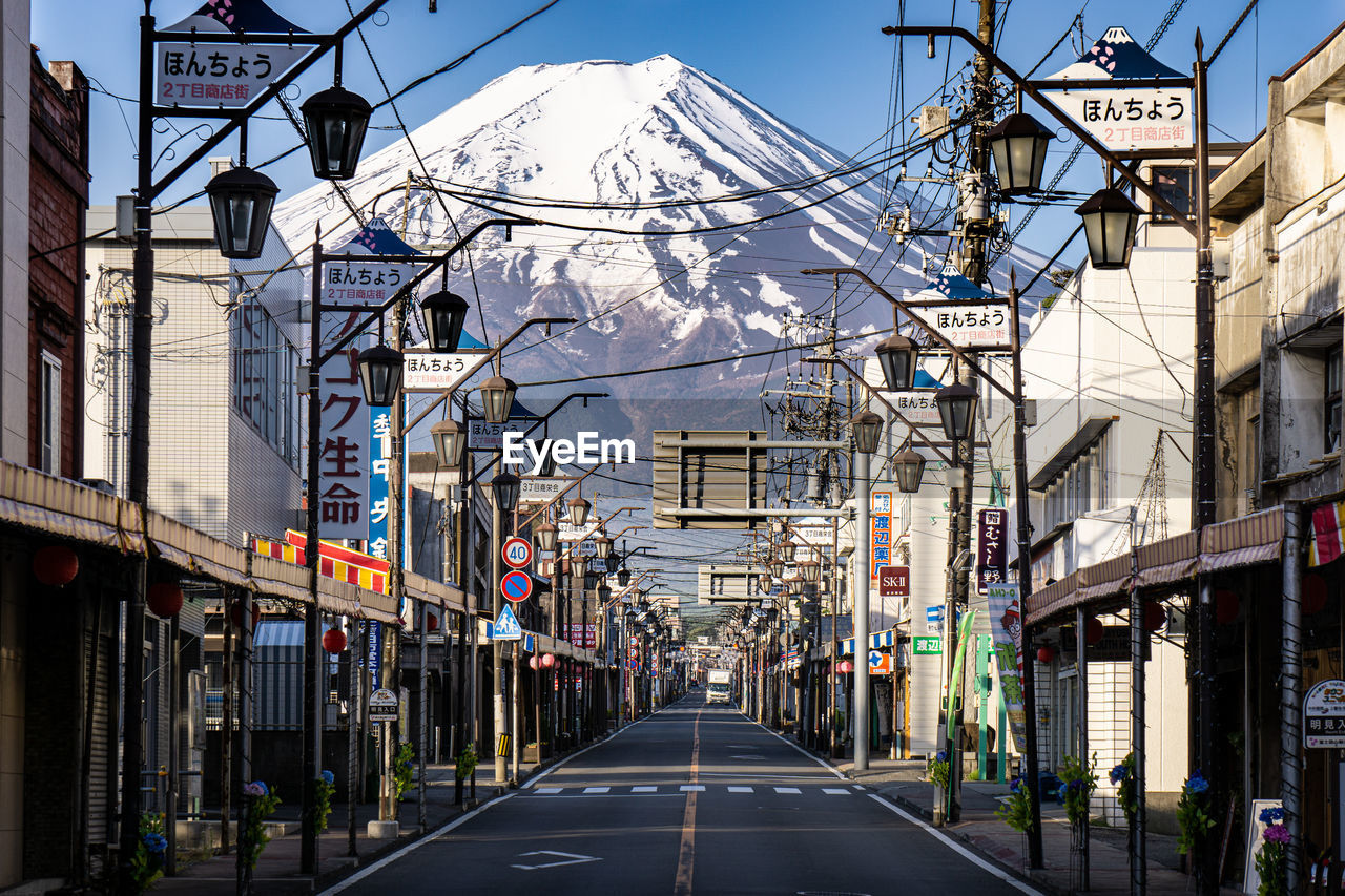 ROAD AMIDST BUILDINGS AGAINST SKY