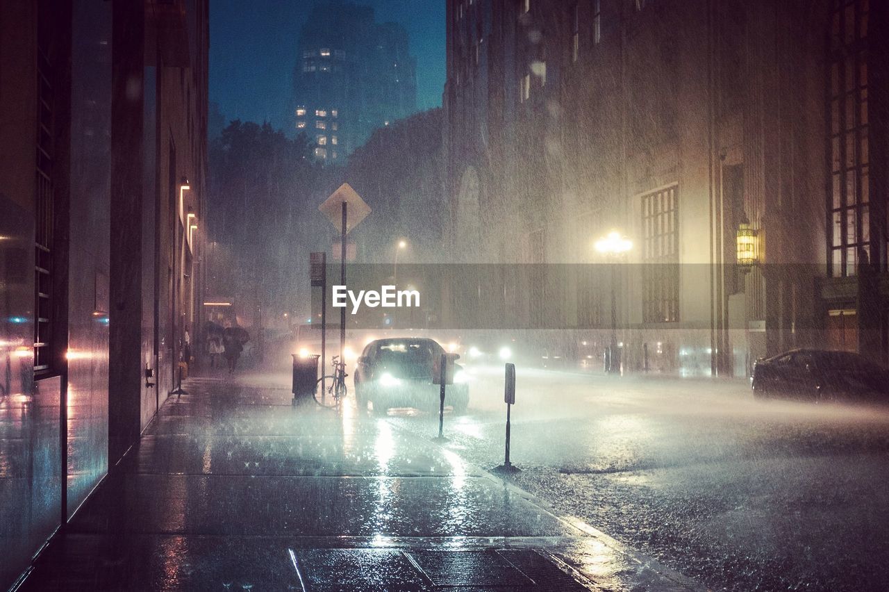 Cars on road in city at night during rainy season