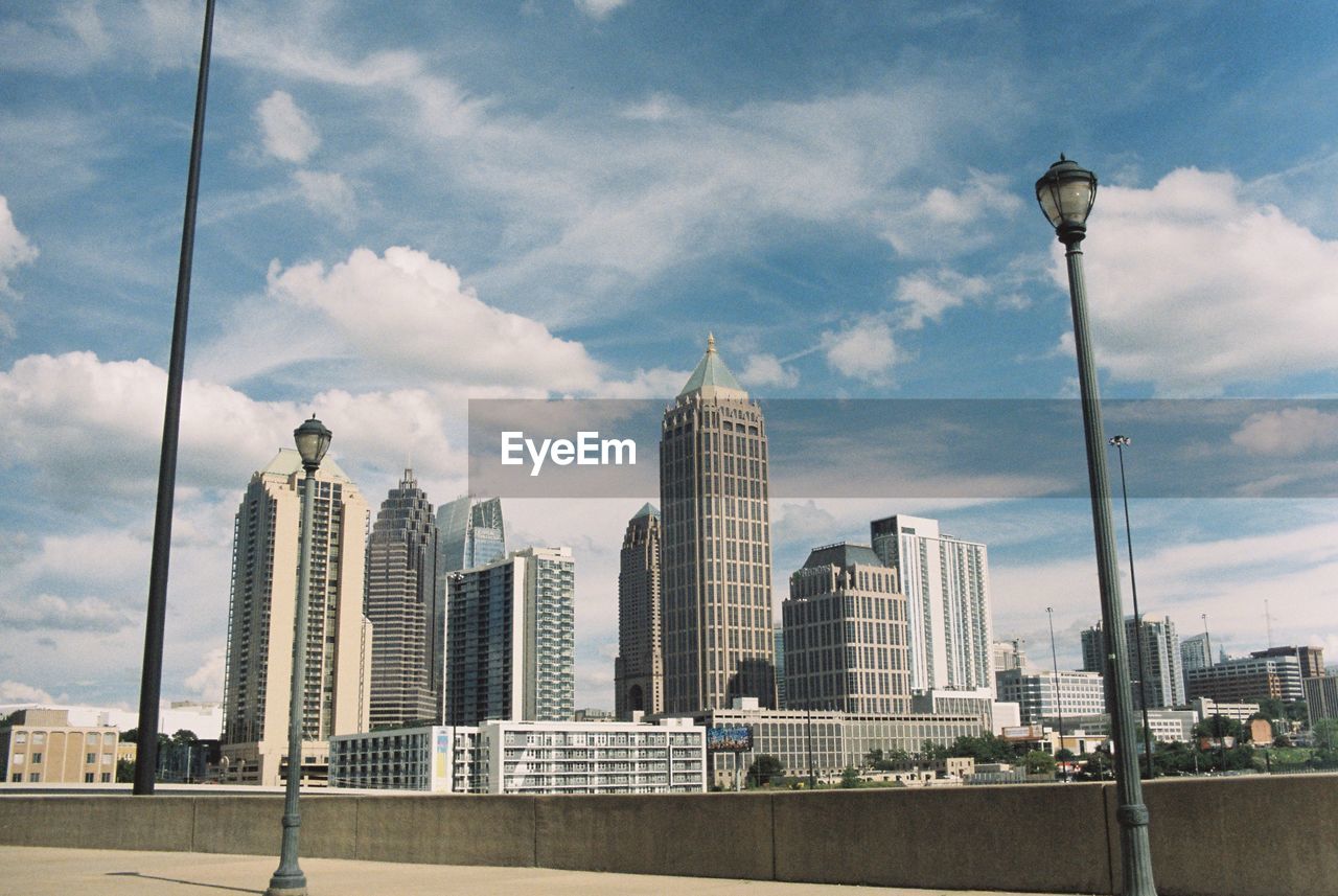 Buildings in city against cloudy sky