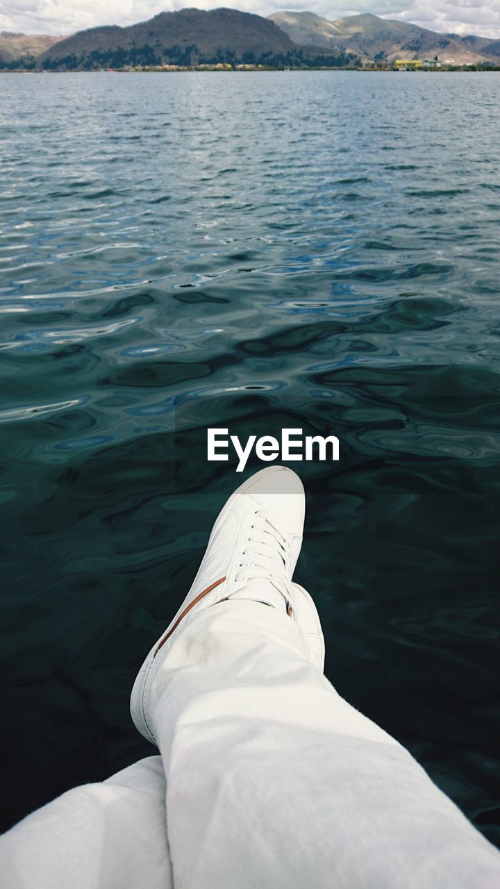 LOW SECTION OF MAN SITTING IN LAKE