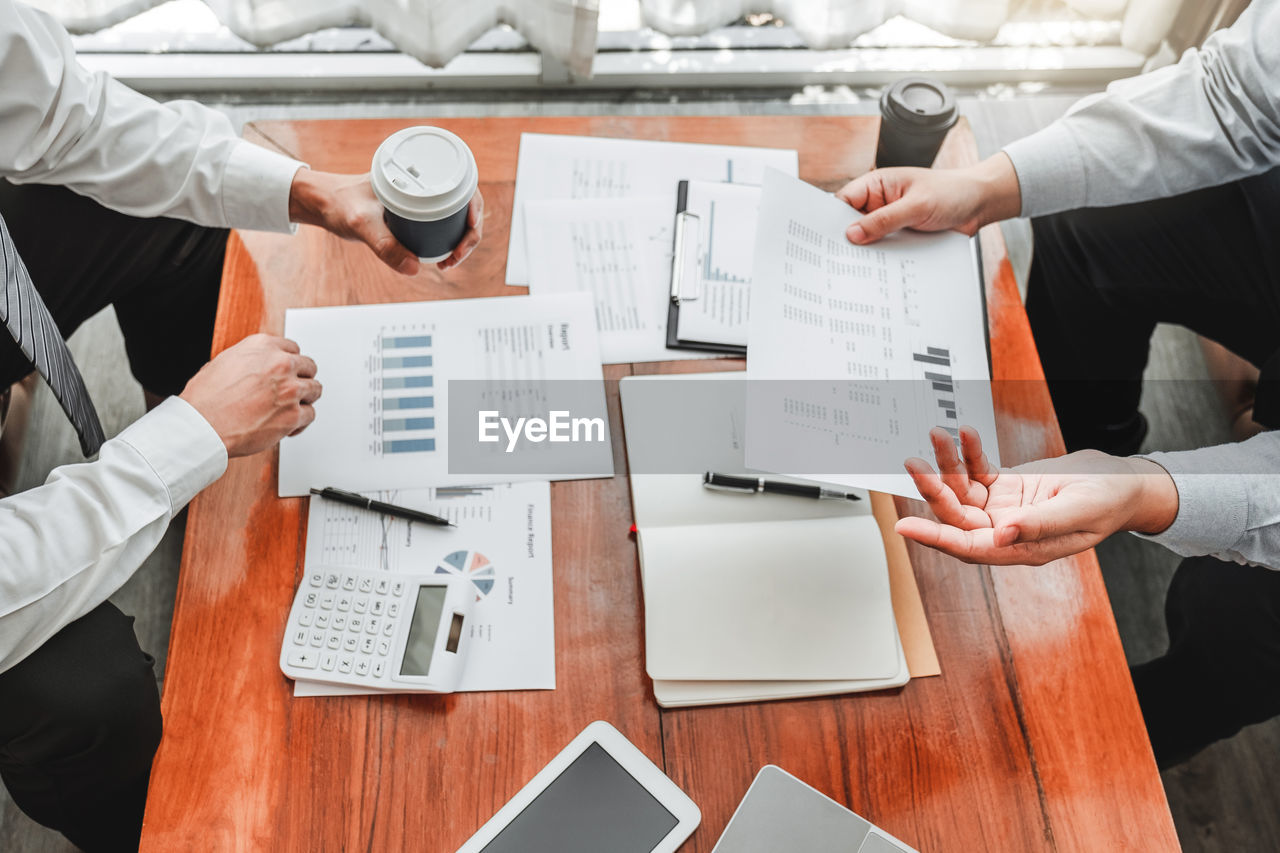 Midsection of business colleagues working at desk in office