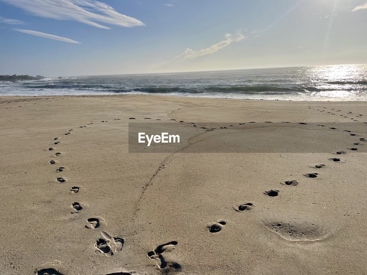 land, beach, sea, sand, water, sky, body of water, nature, footprint, shore, ocean, wave, beauty in nature, coast, scenics - nature, tranquility, sunlight, horizon, environment, horizon over water, motion, landscape, sun, cloud, wind wave, coastline, sunset, tranquil scene, travel destinations, outdoors, vacation, no people, trip, print, holiday, travel, track - imprint, day, summer, water's edge, sunny, animal, sports