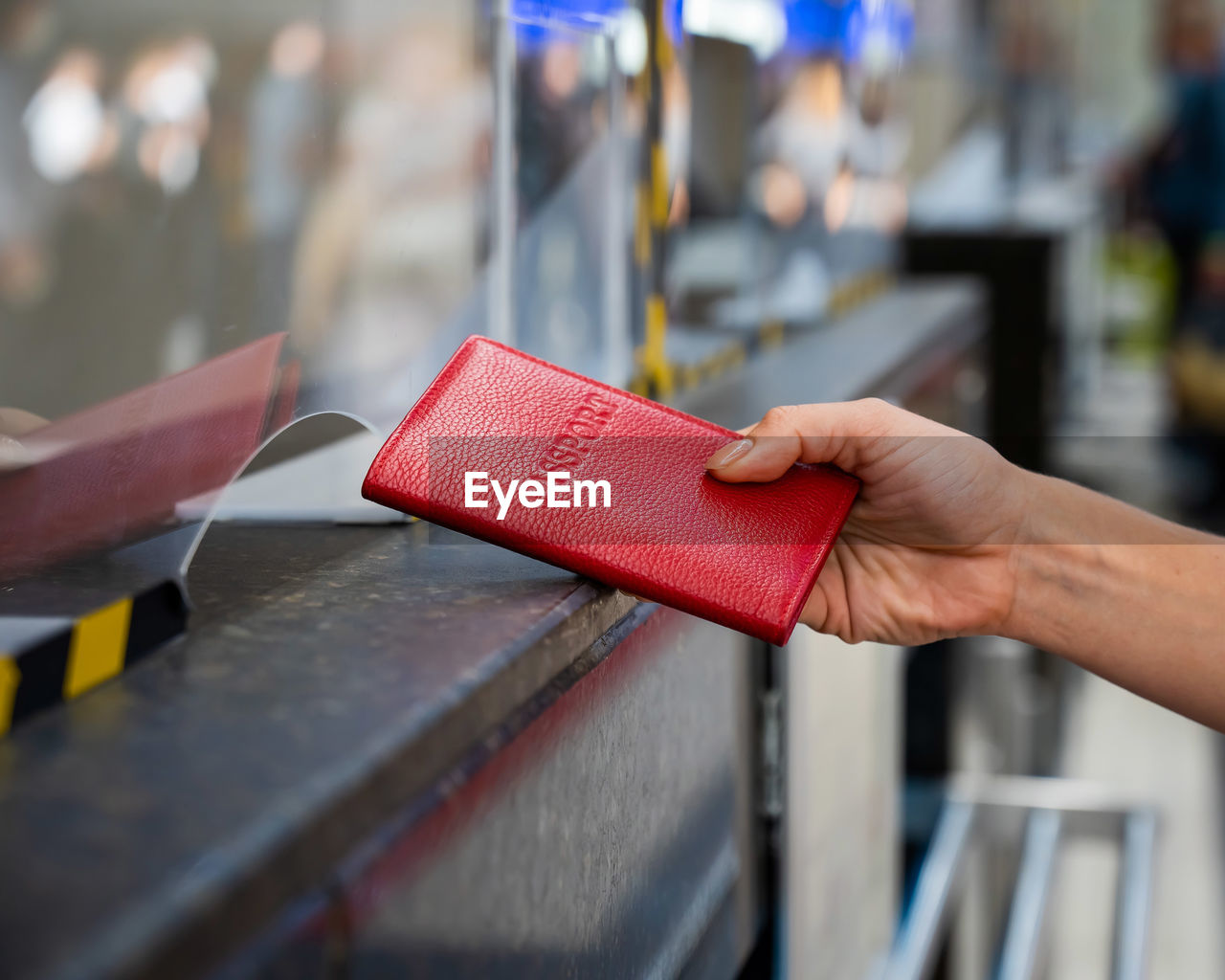 CLOSE-UP OF HAND HOLDING RED BOOK WITH OPEN