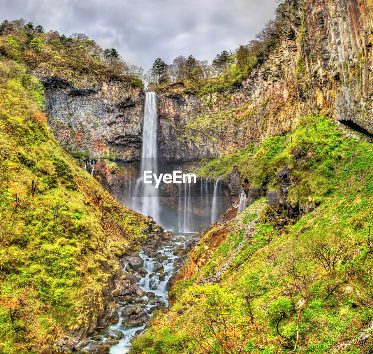 SCENIC VIEW OF WATERFALL AGAINST ROCKS