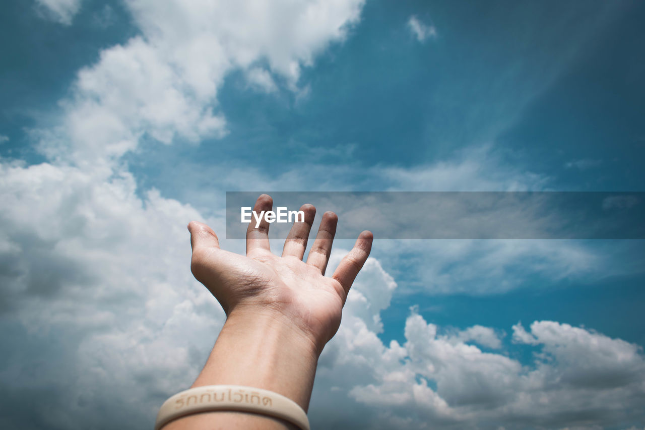 LOW ANGLE VIEW OF HUMAN FEET AGAINST SKY