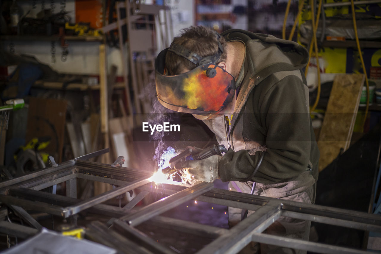 Man welding metal in workshop