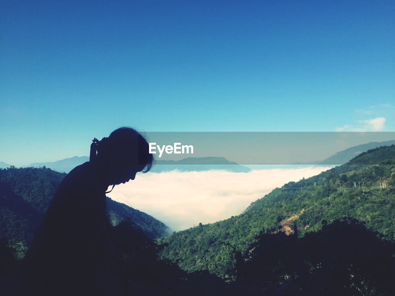 MAN STANDING ON MOUNTAINS AGAINST CLEAR SKY