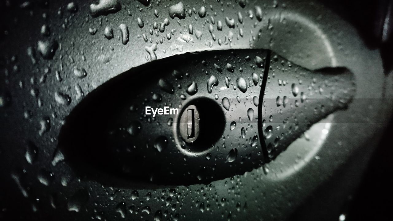 Close-up of raindrops on car handle