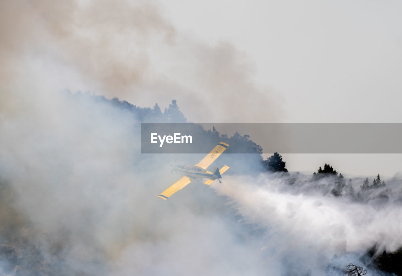 Low angle view of smoke emitting from airplane against sky