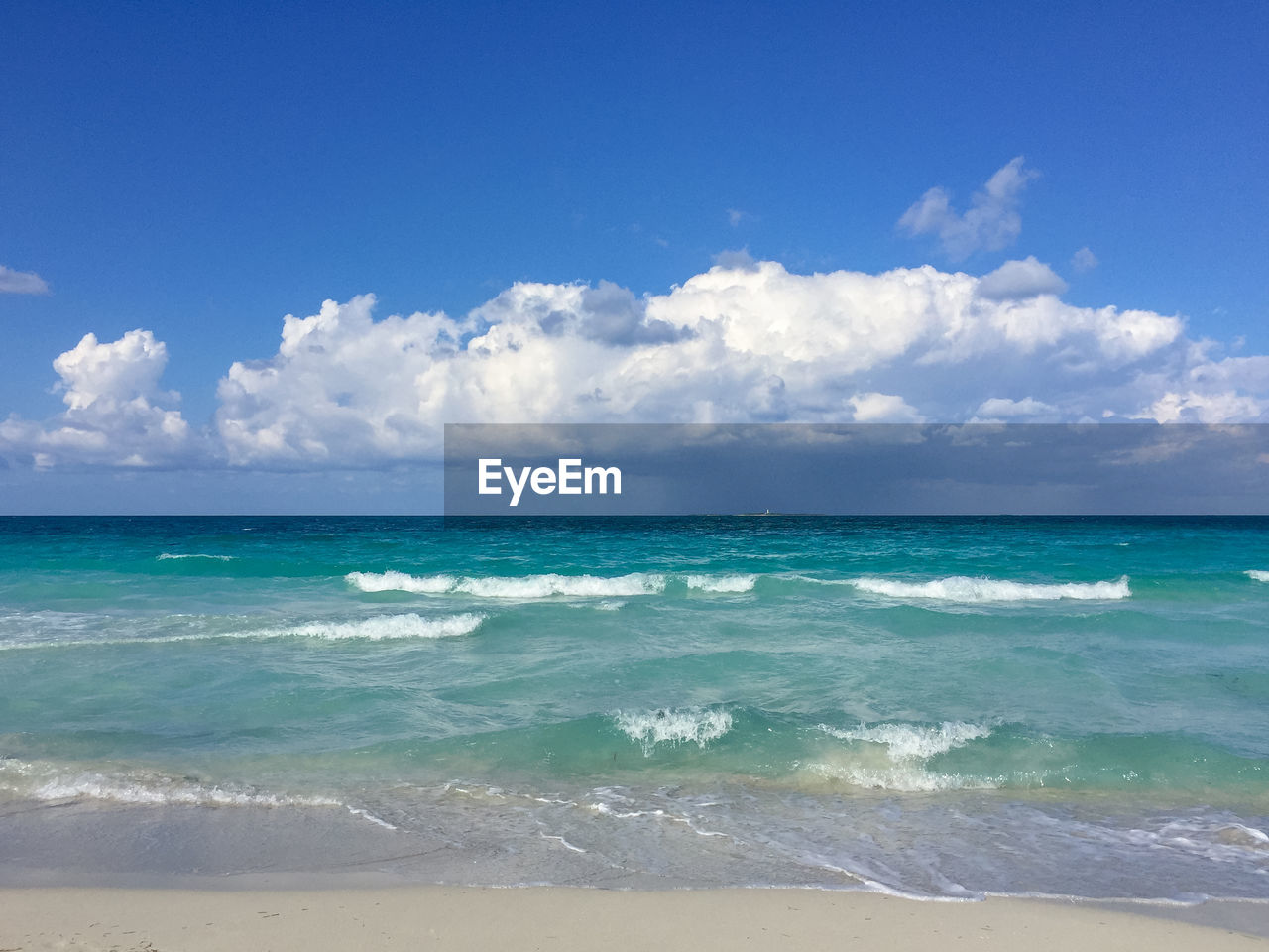 SCENIC VIEW OF BEACH AGAINST BLUE SKY