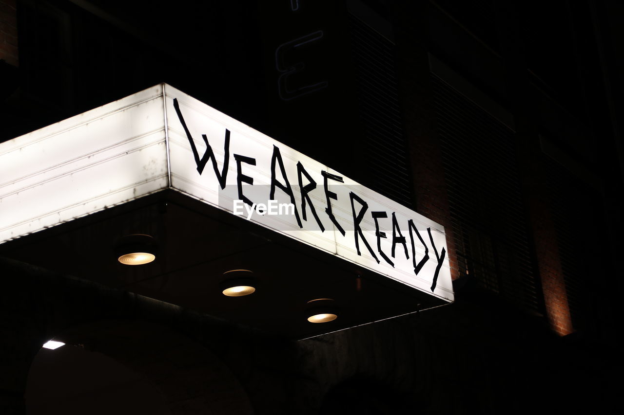 LOW ANGLE VIEW OF ILLUMINATED INFORMATION SIGN