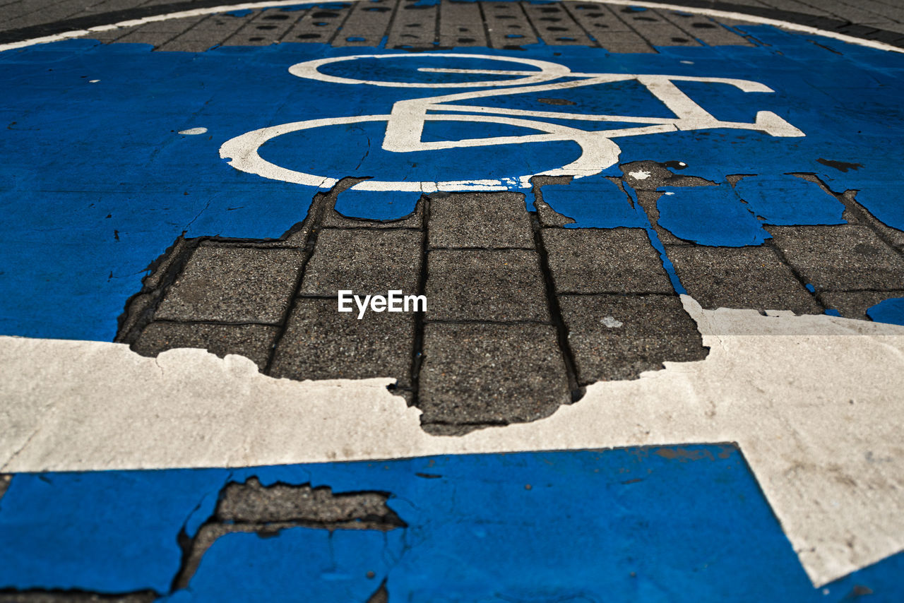 High angle view of arrow sign and bycicle sign on road