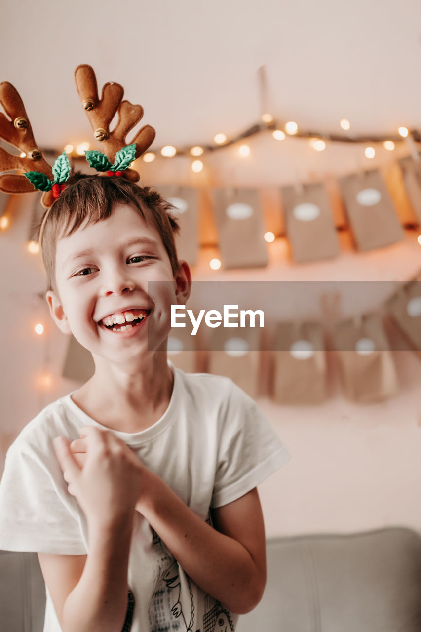 Happy boy greets christmas. christmas mood at home. boy rejoices at christmas. christmas morning. 