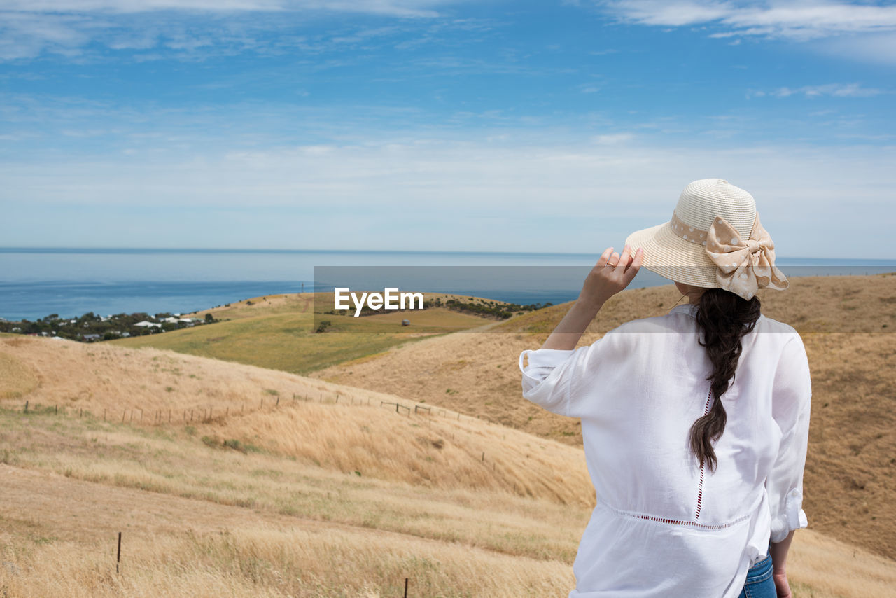 Rear view of woman on land against sky