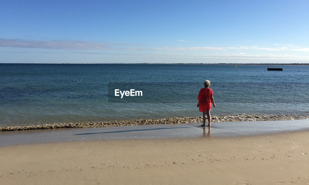 Rear view of woman standing on beach