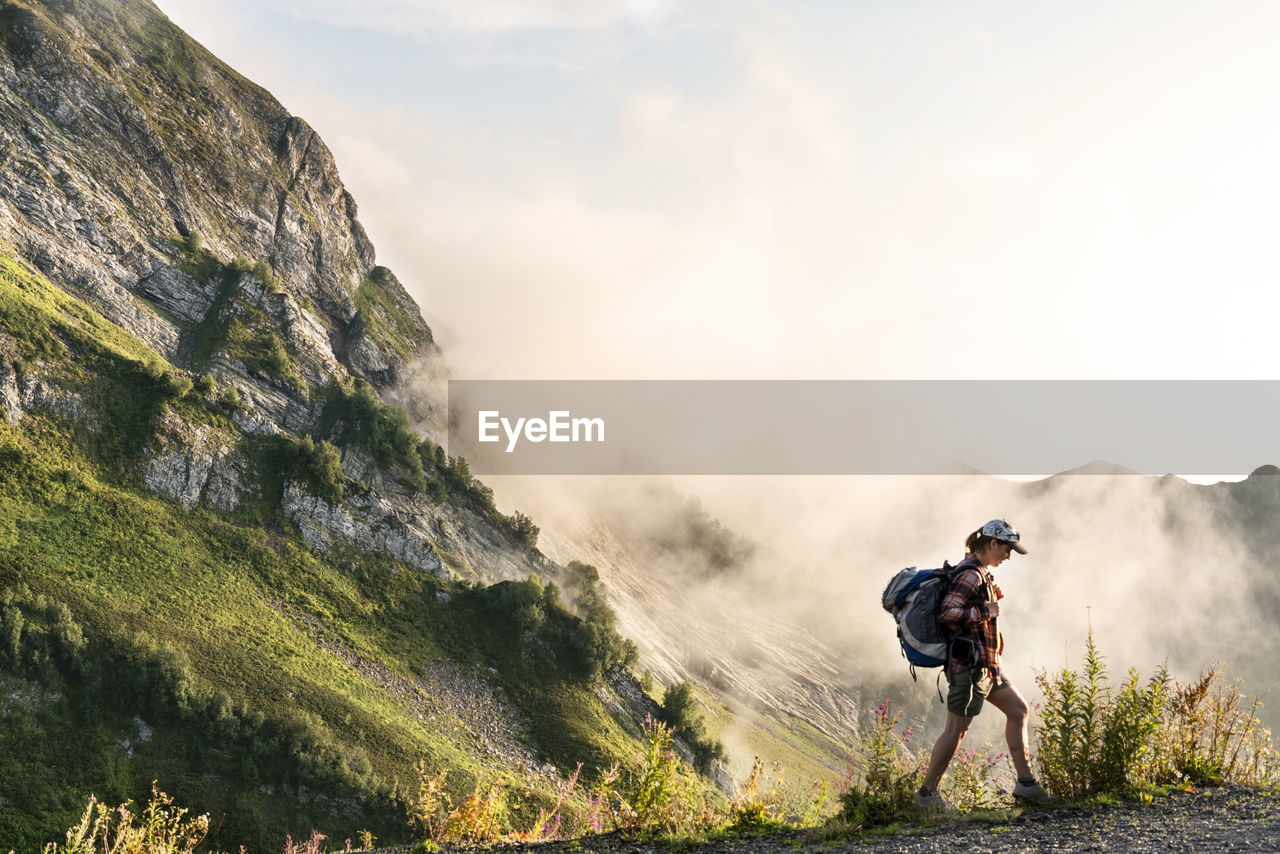 rear view of man riding bicycle on mountain against sky