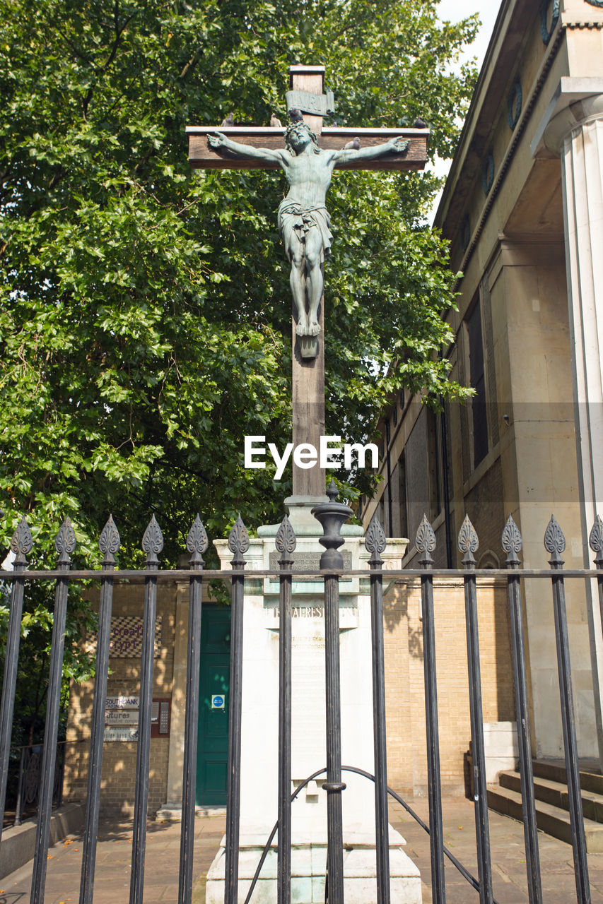 LOW ANGLE VIEW OF STATUE AGAINST TREE