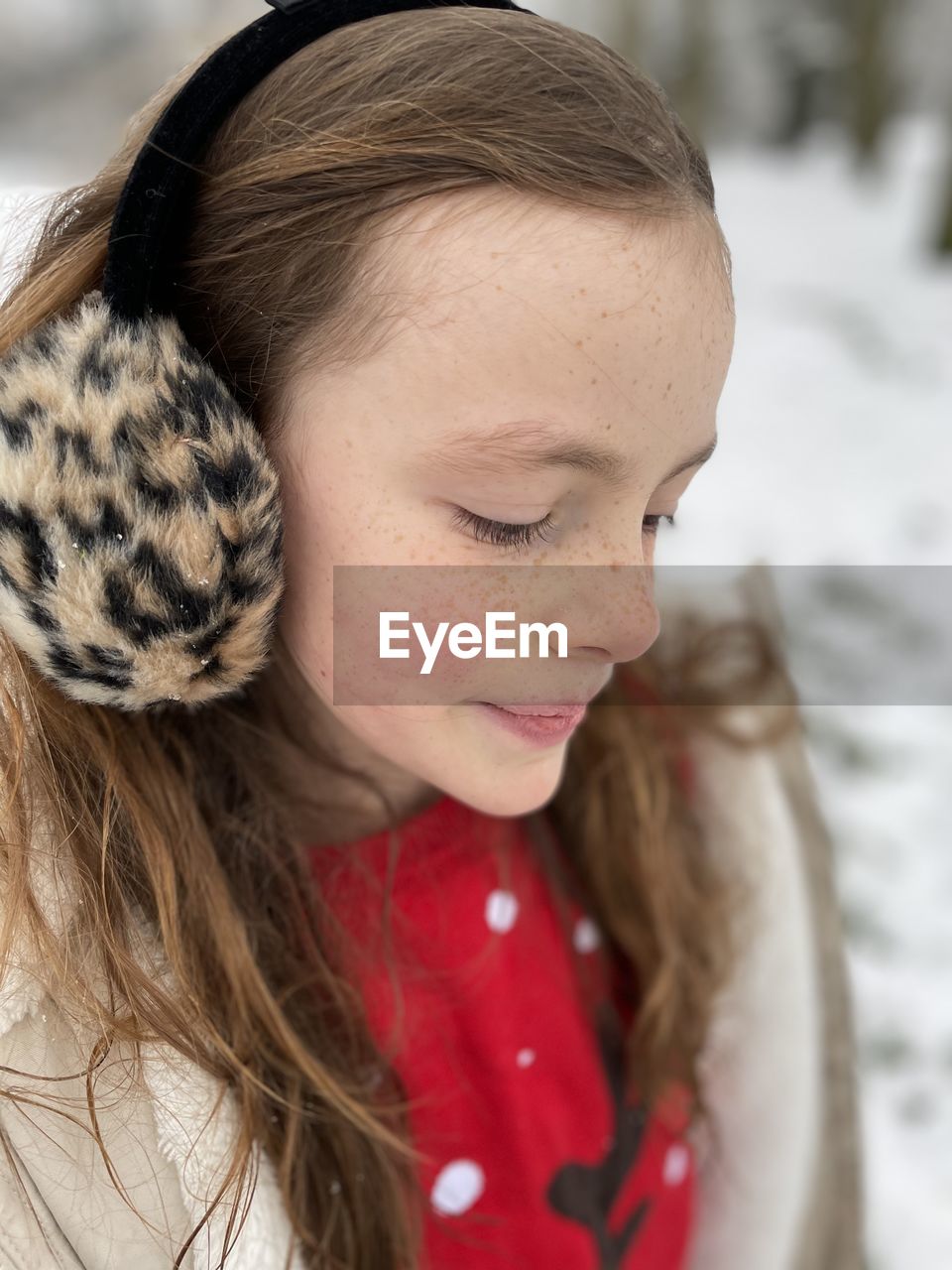 Smiling girl looking down during winter