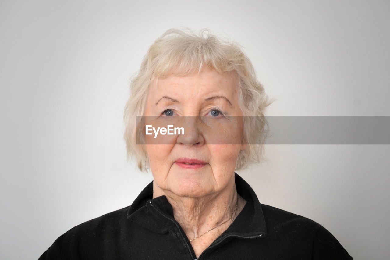 Portrait of old woman against white background