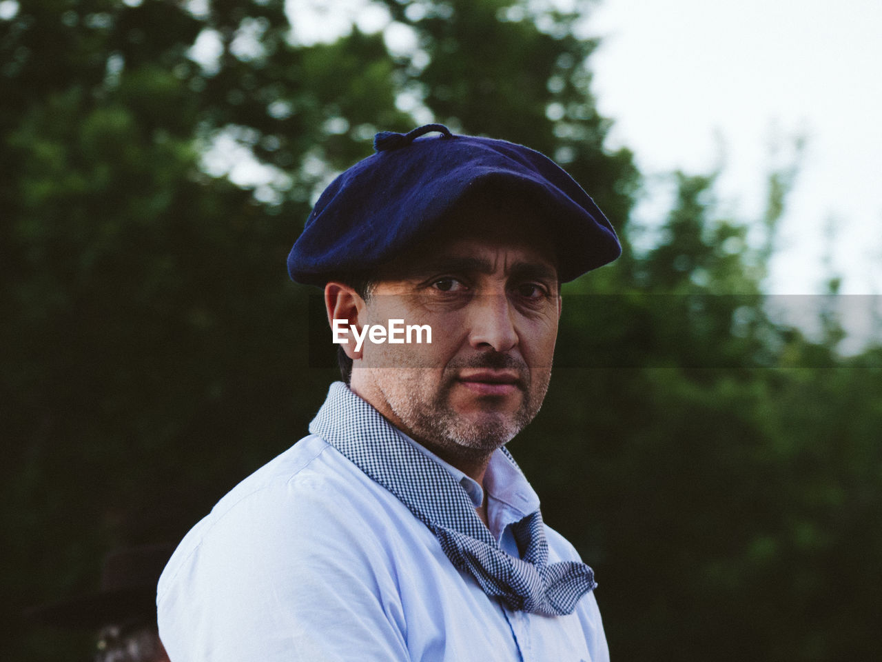 Portrait of man standing against trees