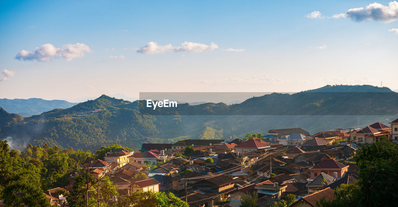 HIGH ANGLE VIEW OF TOWNSCAPE BY MOUNTAIN AGAINST SKY