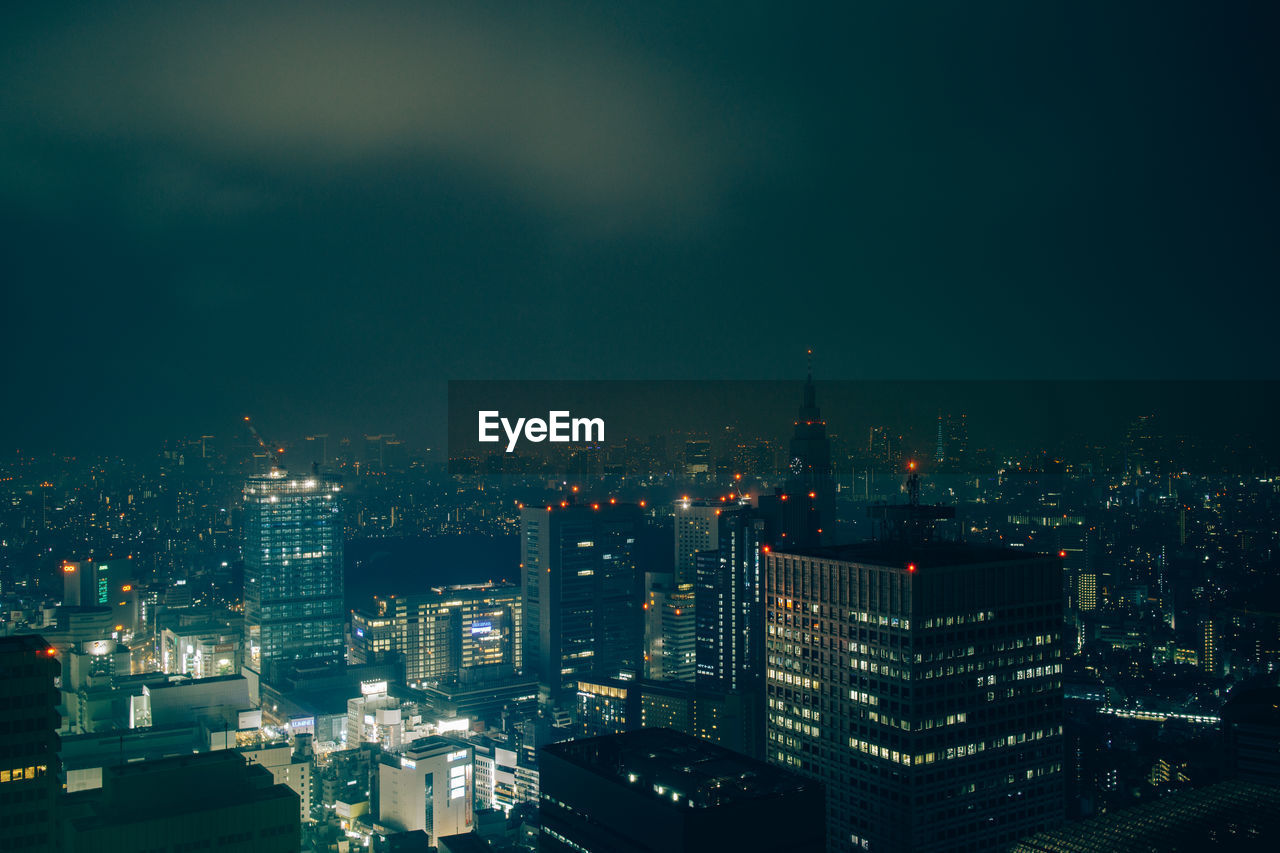 Illuminated cityscape against sky at night