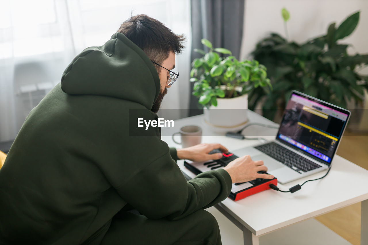 side view of woman using laptop while sitting at office