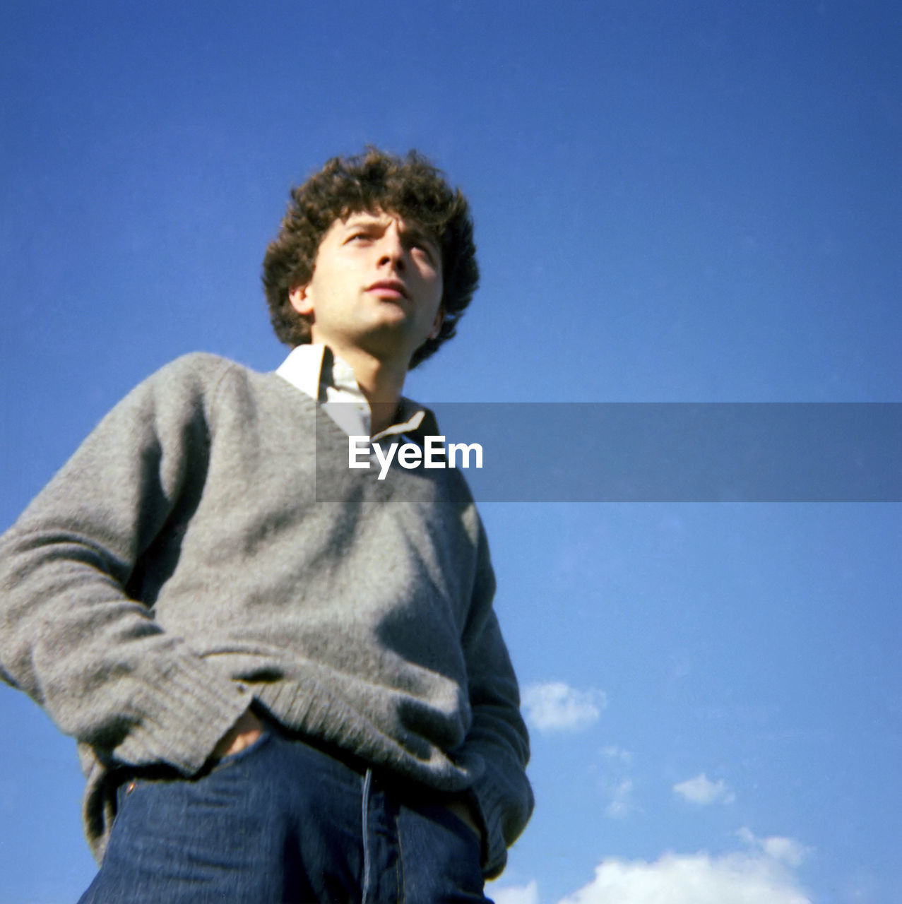 Portrait of young man standing against clear blue sky