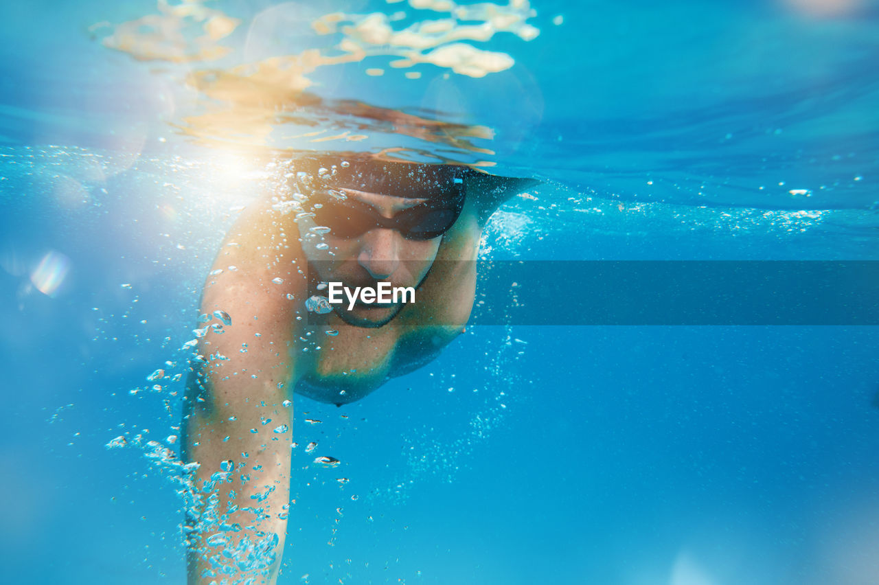 low section of man swimming in sea