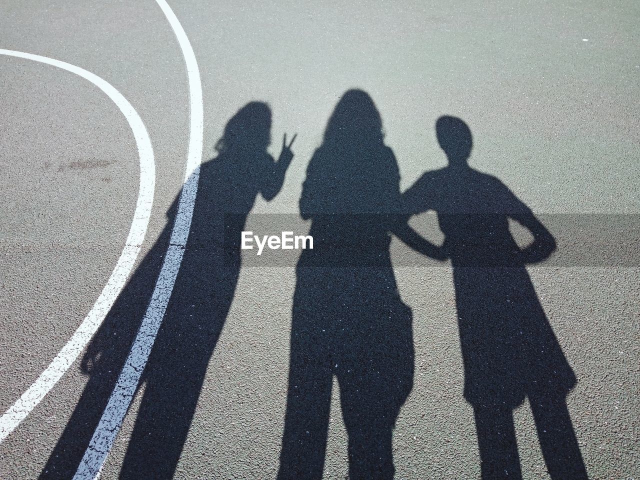 SHADOW OF PEOPLE STANDING ON ROAD