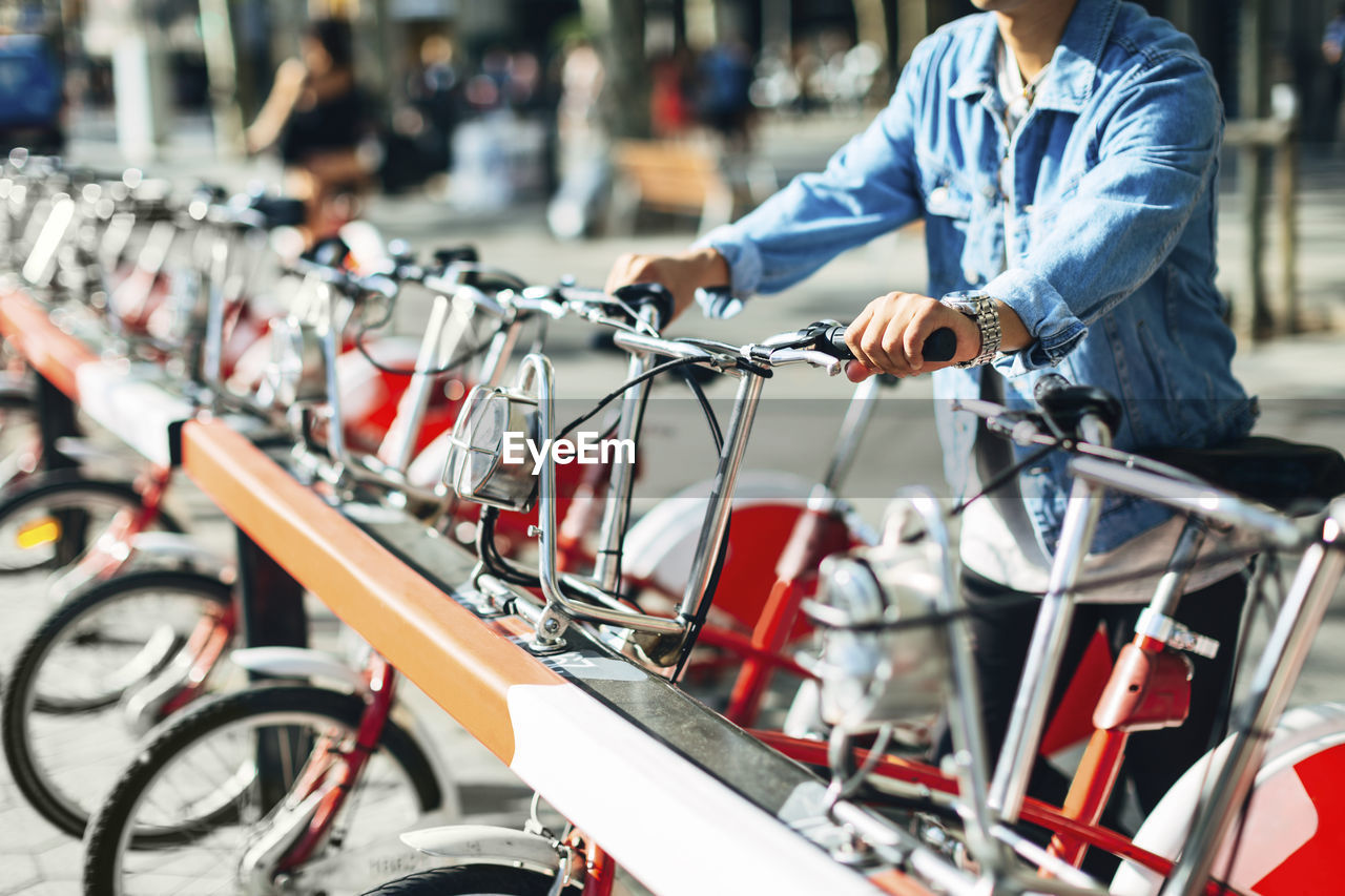 Midsection of man renting bicycle on street