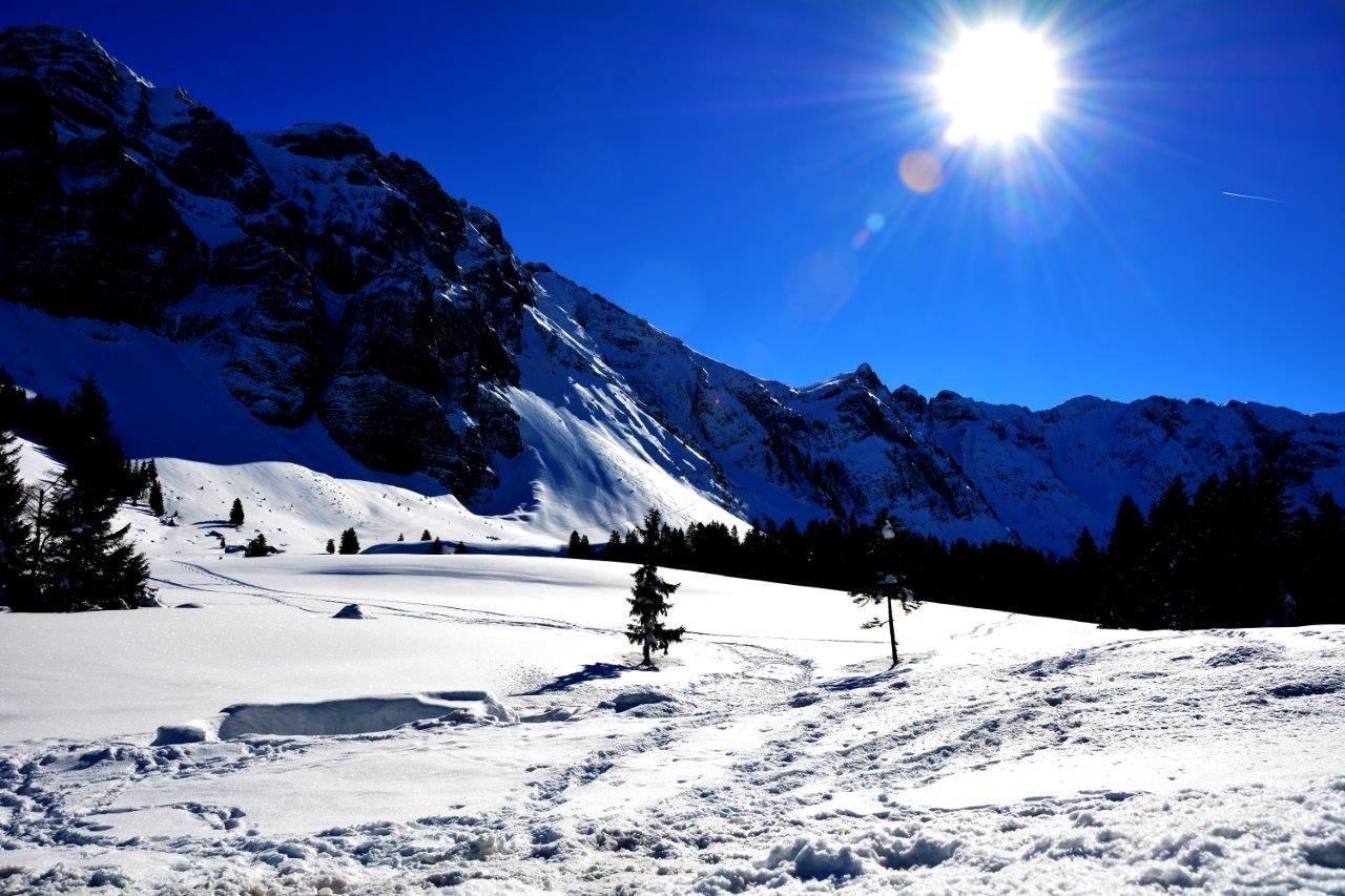 SUN SHINING OVER SNOW COVERED MOUNTAINS