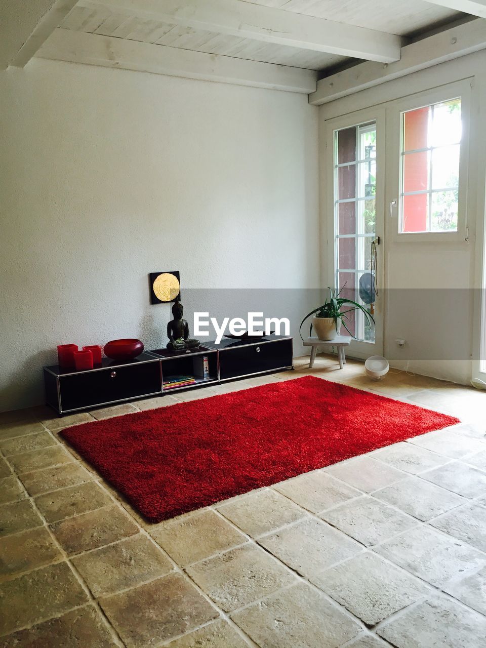 Red rug on tiled floor in living room