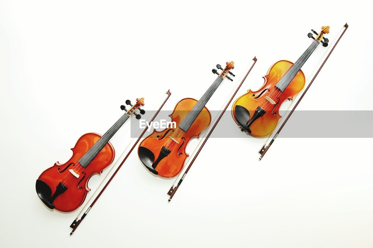 Directly above shot of violins on white background