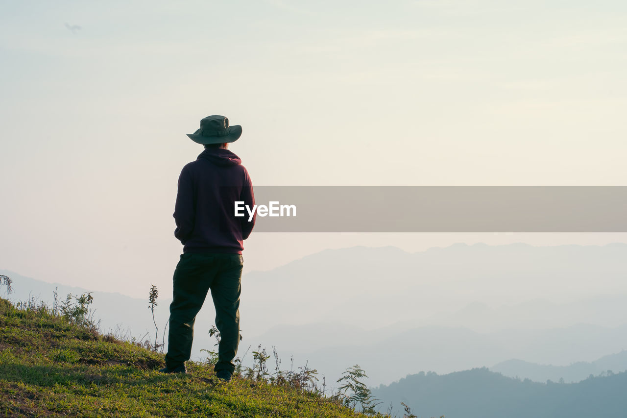 Hiker man relax with wellbeing and happy feeling on top of mountain